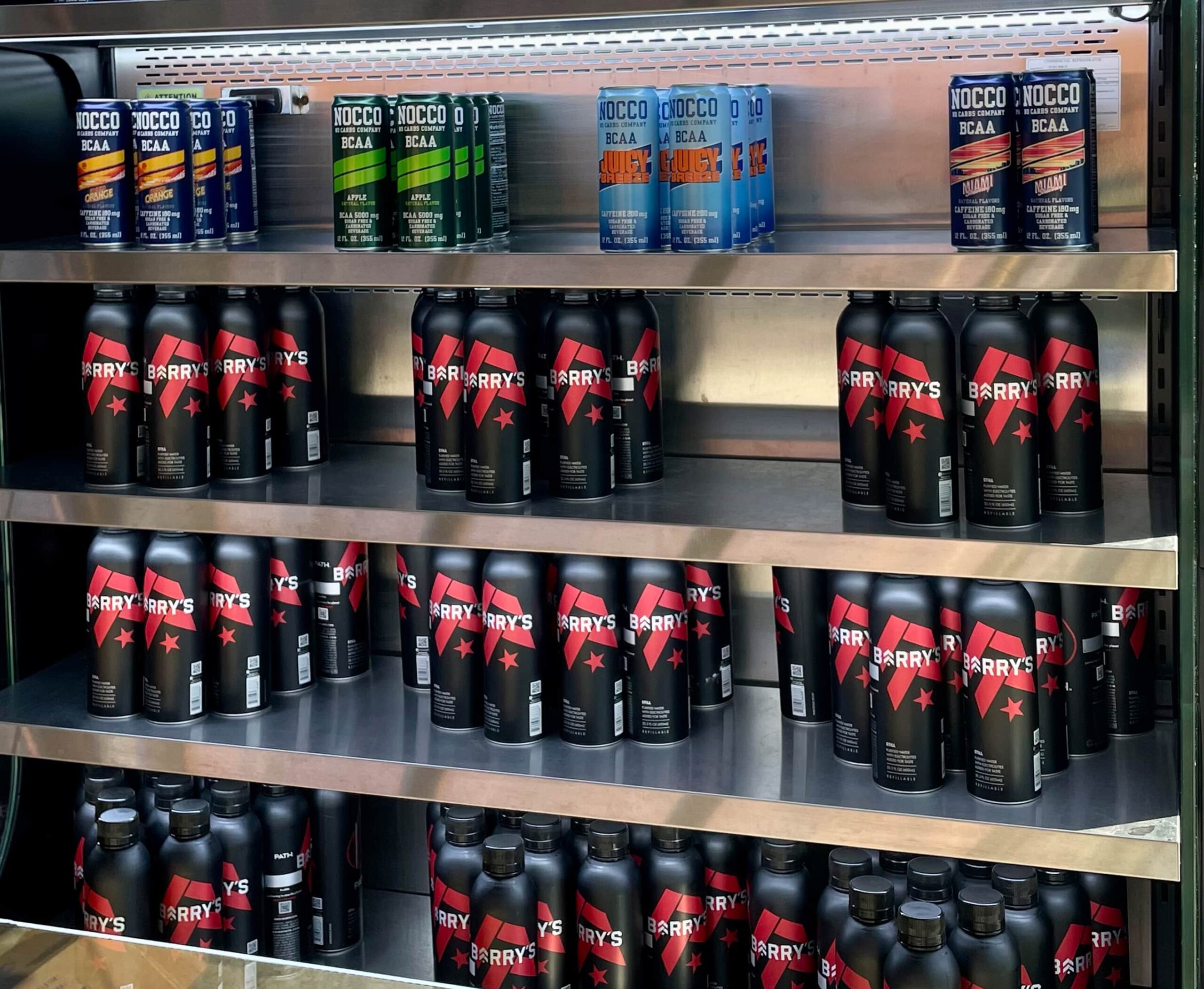 Shelves stocked with Barry's and NOCCO branded beverage bottles.